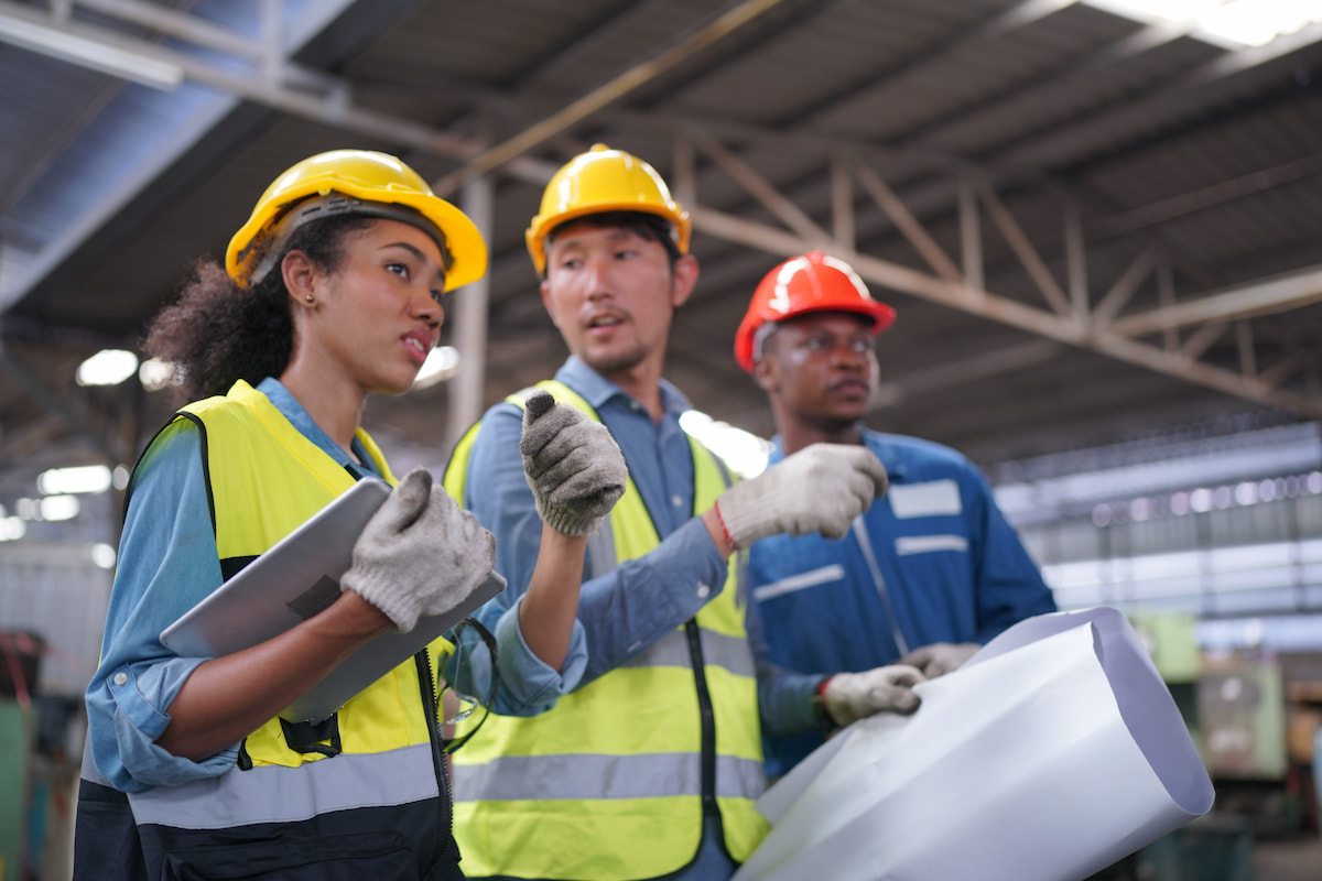 Three workers discussing safety in the workplace