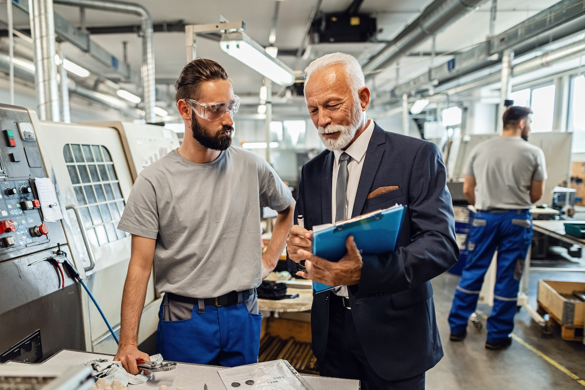 Employee talking with safety coordinator in manufacturing plant