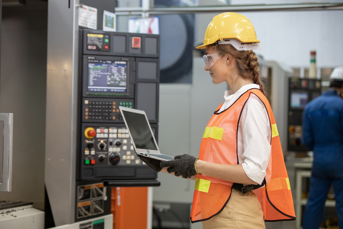 Woman on a laptop reviewing manufacturing equipment